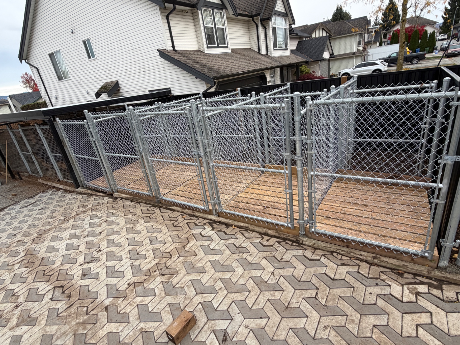 Galvanized chain link dog kennel enclosure built on a wooden deck