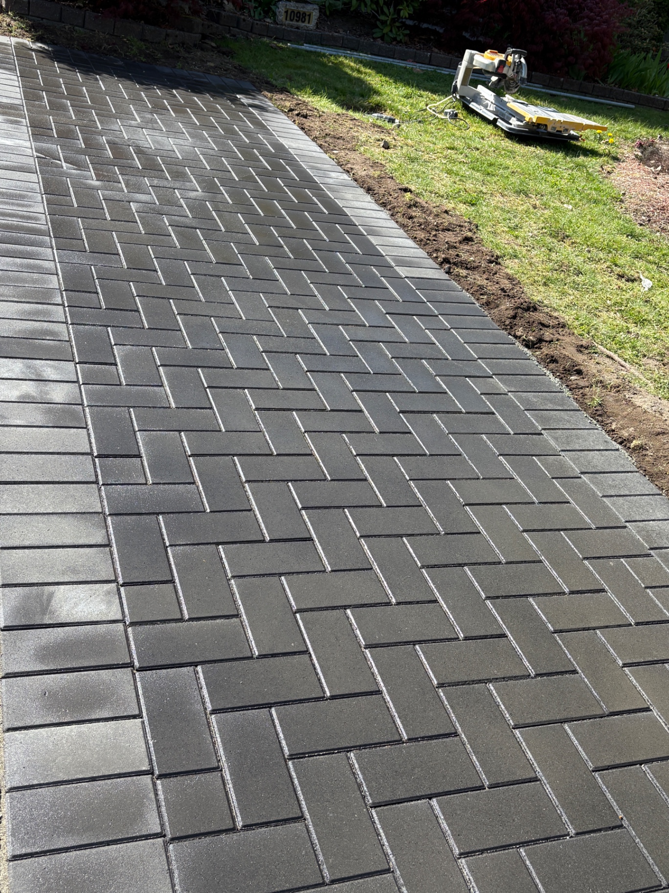 Charcoal herringbone paver walkway with contrasting border running to a front entry