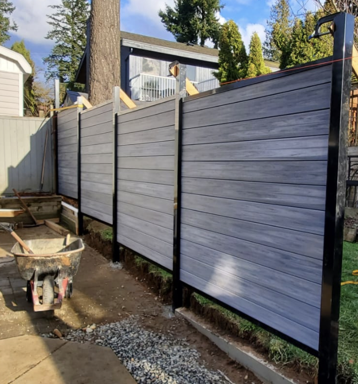 Horizontal grey woodgrain composite fence panels set in black aluminum posts