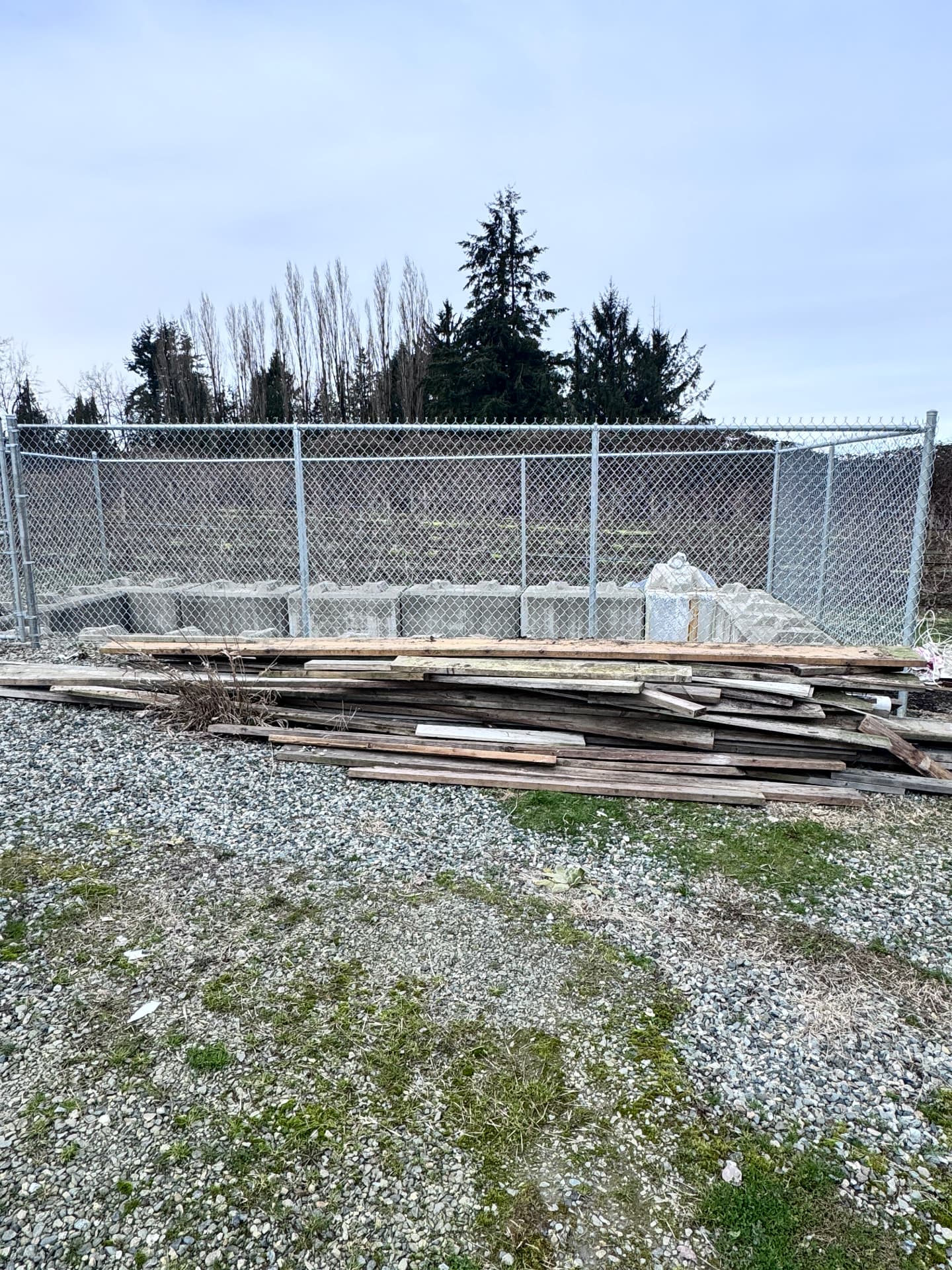 Tall galvanized chain link fence enclosing a commercial storage yard