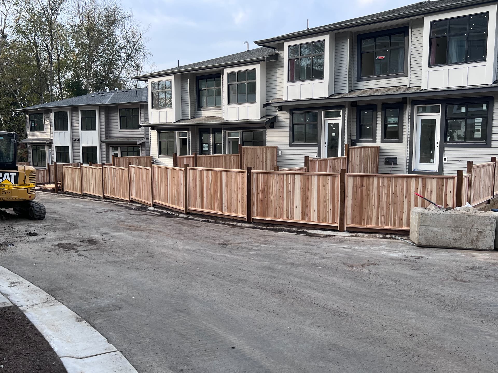 Cedar privacy fence panels and gates installed across a new townhouse development