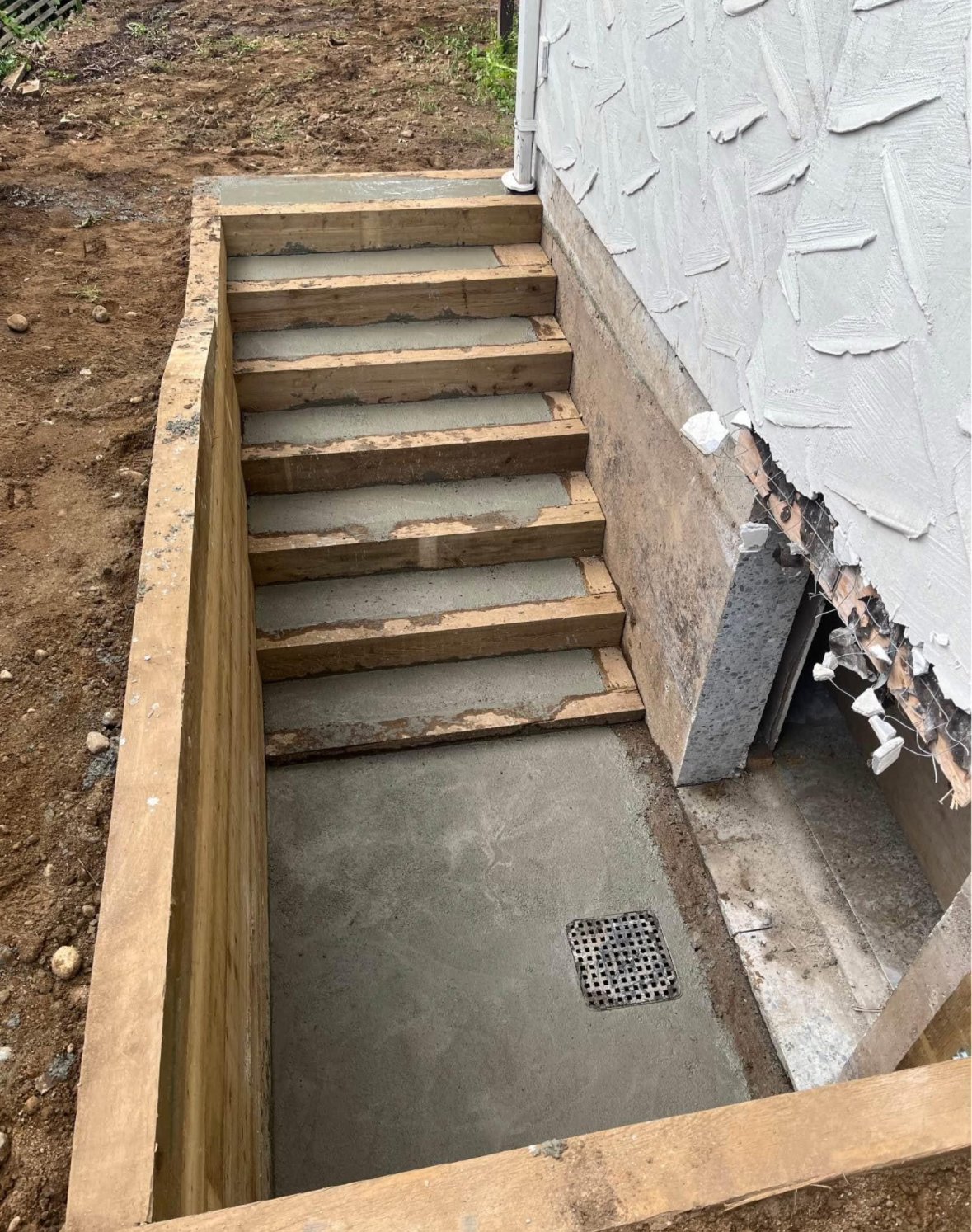 Formed and poured concrete basement stairs with wood framing