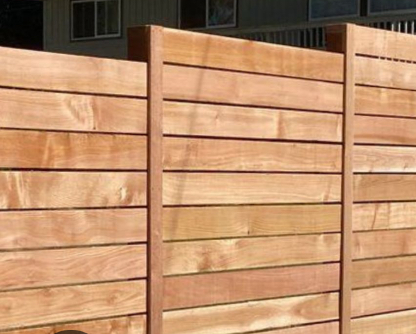 Close-up of horizontal cedar fence boards with gapped spacing